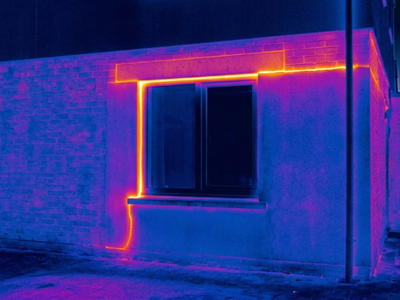 Thermal image of a window reveal and lintel showing a thin warm line where heat is bridging through the structure