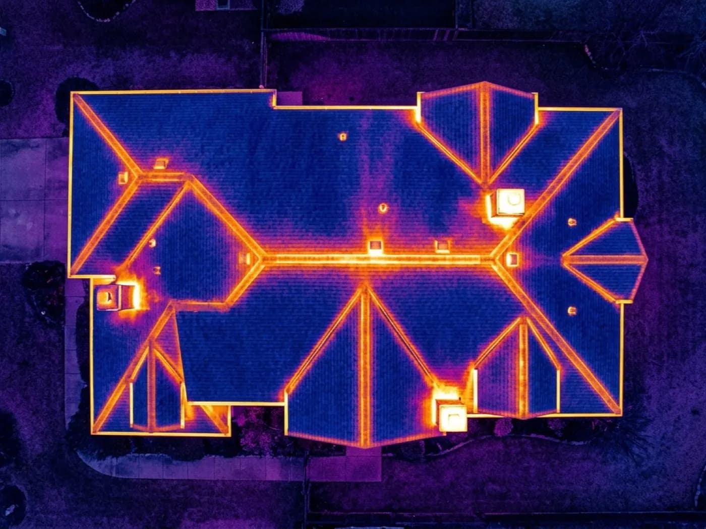 Aerial thermal camera image of a whole house roof in ironbow false colour, showing warmer areas near the ridge against a cooler roof field